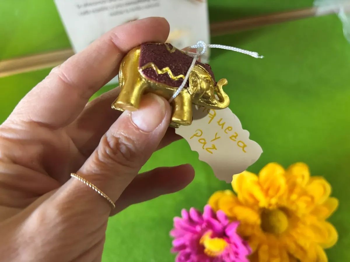 Mano sujetando una figura de un elefante dorado