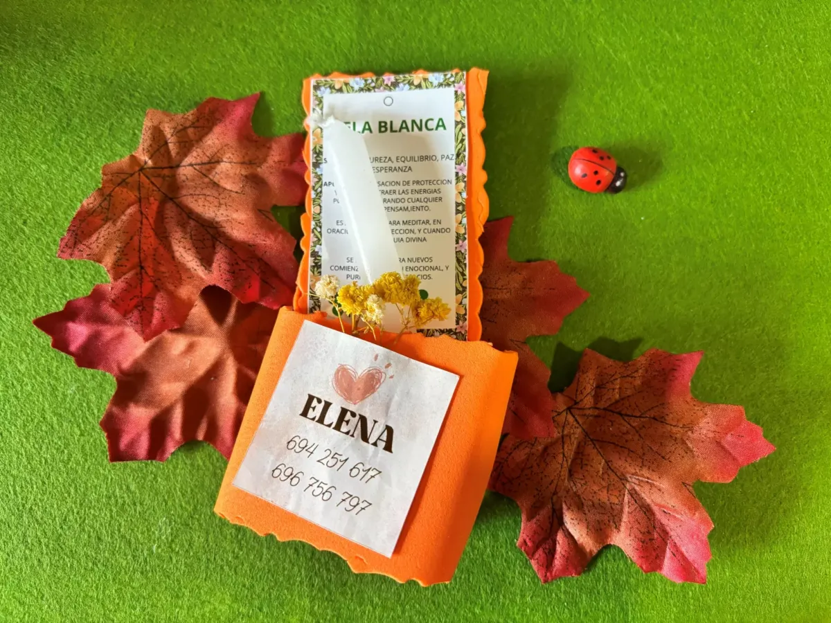 Vela blanca en embalaje sobre hojas rojas