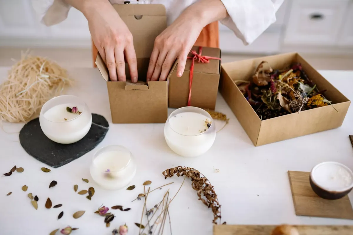 Manos de mujer mientras empaqueta velas